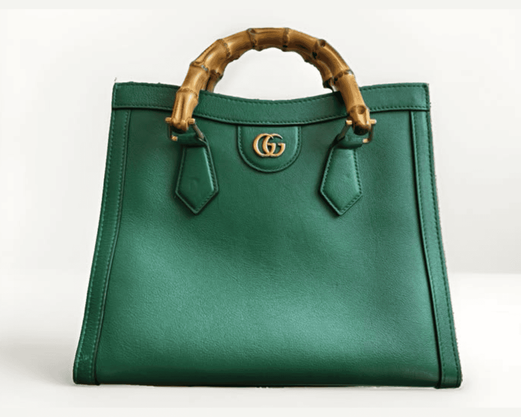 Gucci Diana small tote bag in emerald green grained leather featuring a fire-curved bamboo top handle, gold-tone Double G hardware, and a structured trapezoid silhouette.