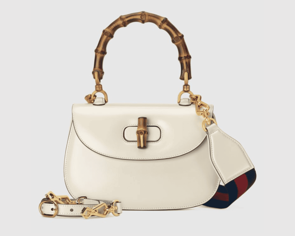 Gucci Bamboo 1947 small top handle bag in white smooth leather featuring a fire-curved natural bamboo handle, a matching bamboo turnlock closure, and dual detachable shoulder straps.