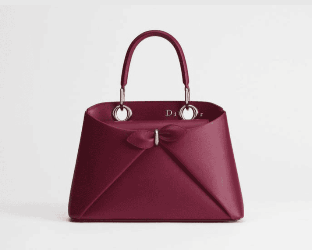 Dior Cigale medium top handle bag in deep burgundy plum calfskin leather featuring a structured origami envelope front with a central bar accent and silver-tone hardware loops.