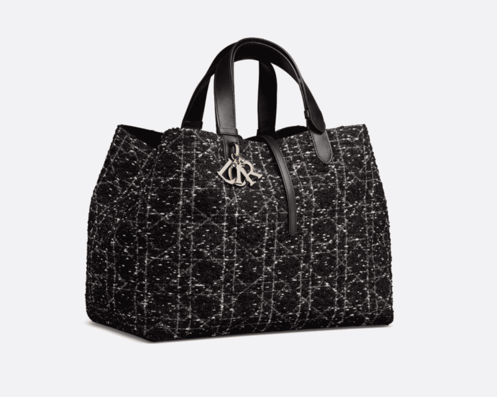 Medium Dior Toujours tote bag in textured black and white tweed Cannage motif featuring adjustable black leather top handles, a crossover strap with CD Lock clasp, and gold-finish metal D.I.O.R. charms.