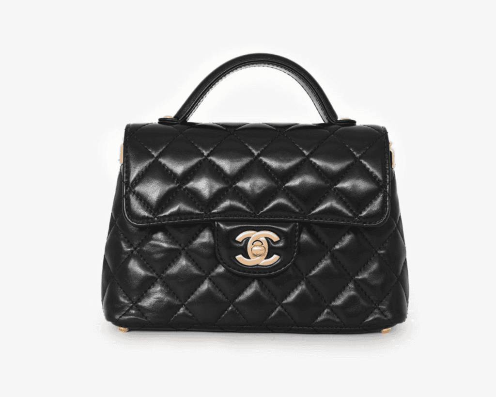Chanel 25P Mini Kelly top handle flap bag in black quilted lambskin leather featuring an interlocking gold CC turnlock and a structured trapezoid silhouette.