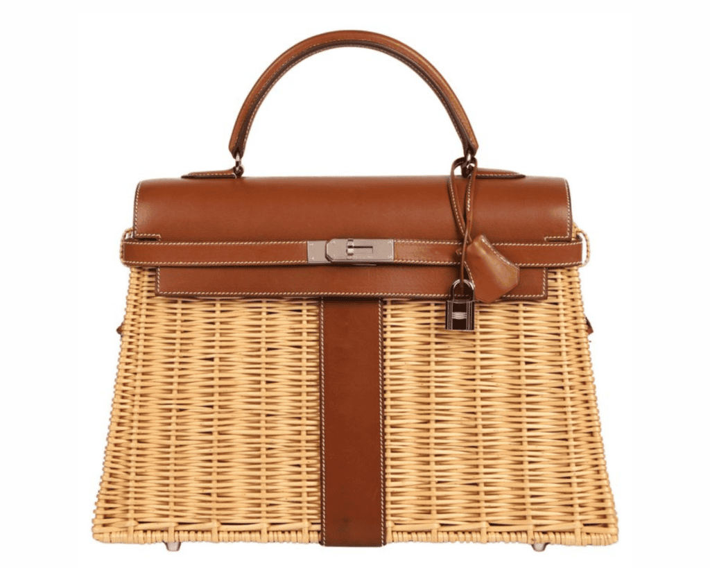 A studio front shot of an Hermès Kelly 35 Picnic bag, highlighting a light tan hand-woven Osier wicker basket body accented by rich brown Barenia leather trim, a smooth leather top flap, a single structured top handle, and a central polished silver-tone palladium turnlock closure with a hanging leather clochette and padlock.