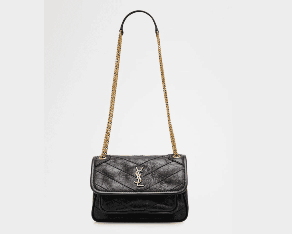 A black crinkled leather Saint Laurent Niki Mini shoulder bag Neiman Marcus with chevron quilt stitching Saint Laurent, featuring a silver-tone interlocking YSL Cassandre logo on the front envelope flap and a gold-tone sliding curb chain strap Neiman Marcus, Base Blu.