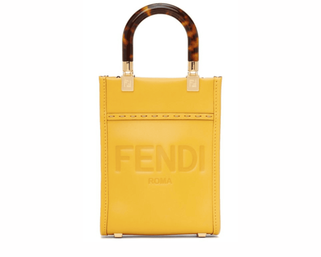 A small, structured bright yellow leather Fendi Sunshine Shopper tote bag FARFETCH, What Goes Around NYC featuring hot-stamped "FENDI ROMA" lettering on the front CLOTHBASE, arched tortoiseshell-effect plexiglass top handles What Goes Around NYC, and gold-tone metal hardware studs along the rim What Goes Around NYC.